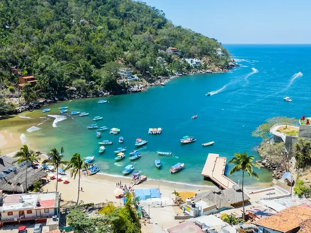 Aerial view of Boca de Tomatlán, with the beach, pangas and small village surrounded by jungle