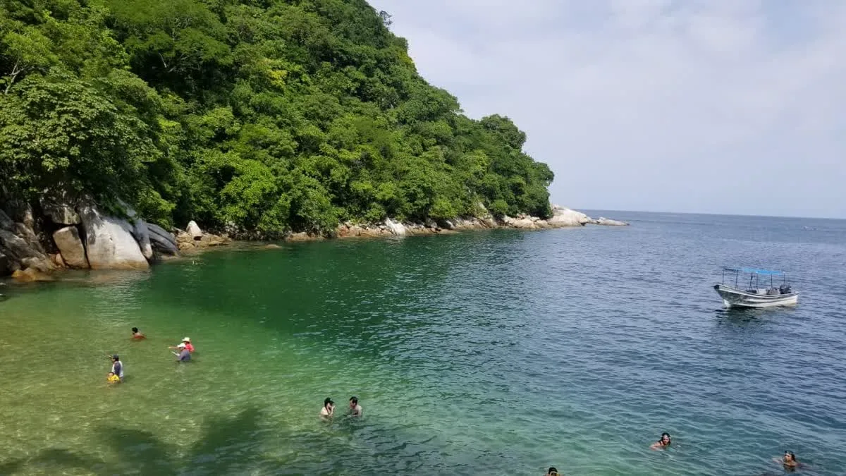 Aerial view of Colomitos beach with snorkelers and a private boat
