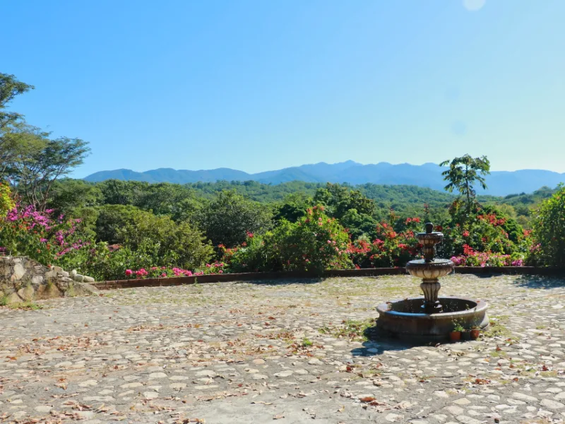 Stone fountain and plaza with mountain views and bougainvillea