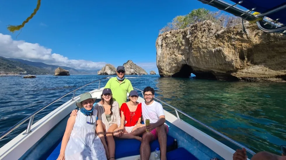 Guests aboard the boat with the Los Arcos rock arches in the background