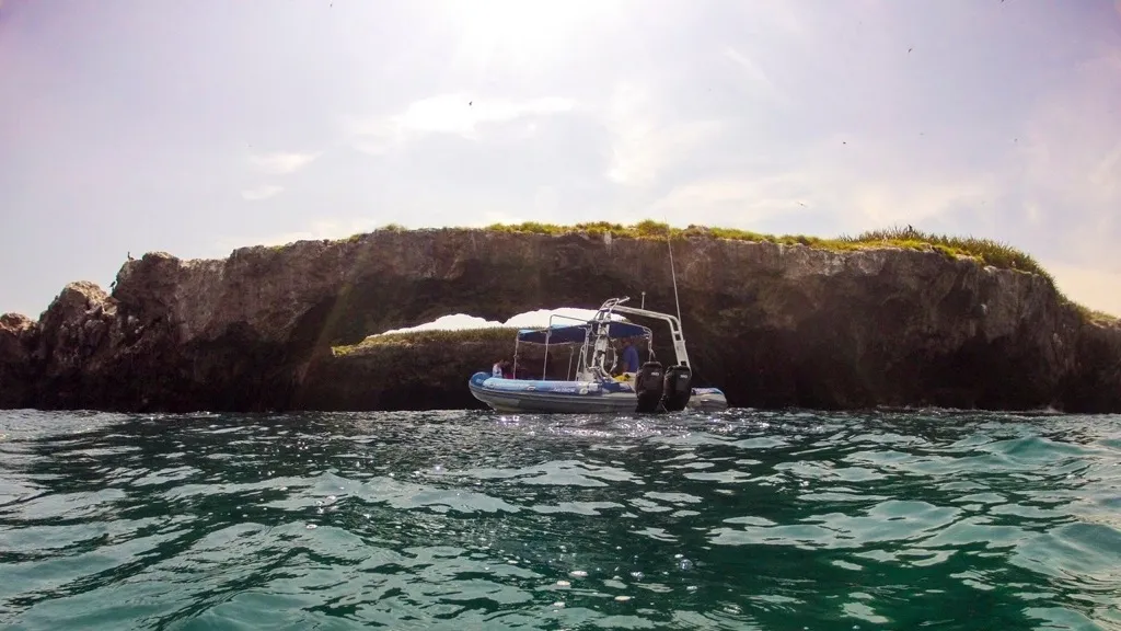 Tour boat approaching the rock arch at Islas Marietas