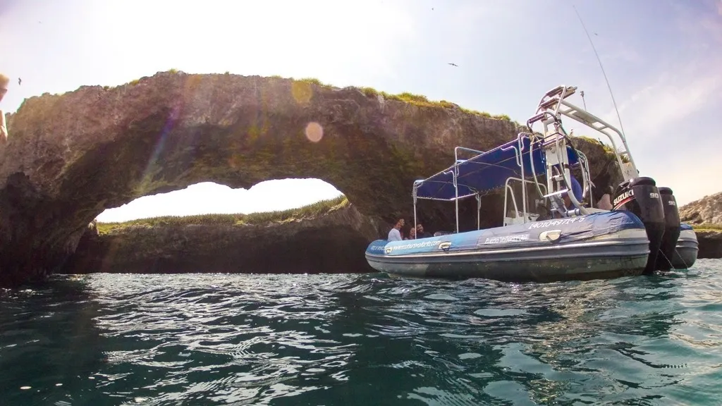 Tour boat passing beneath the rock arch at Islas Marietas