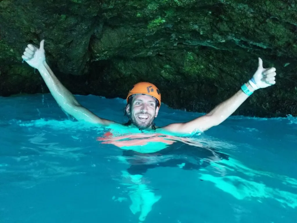 Snorkeler giving a thumbs up in the turquoise cave pool