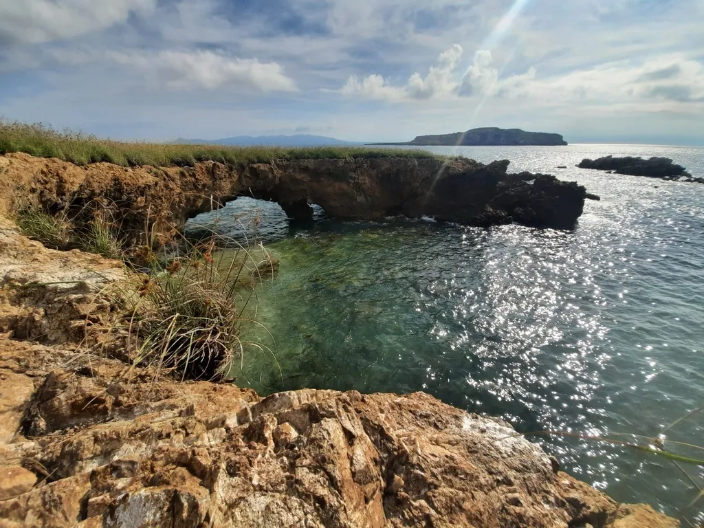 View of a natural rock pool and arch from the cliffs at Islas Marietas