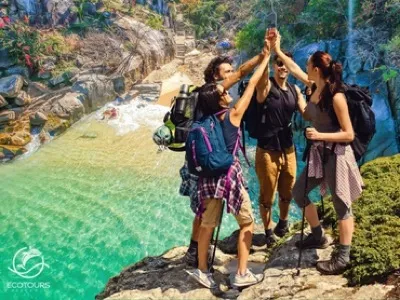 Hikers high-fiving above a jungle river pool near Puerto Vallarta