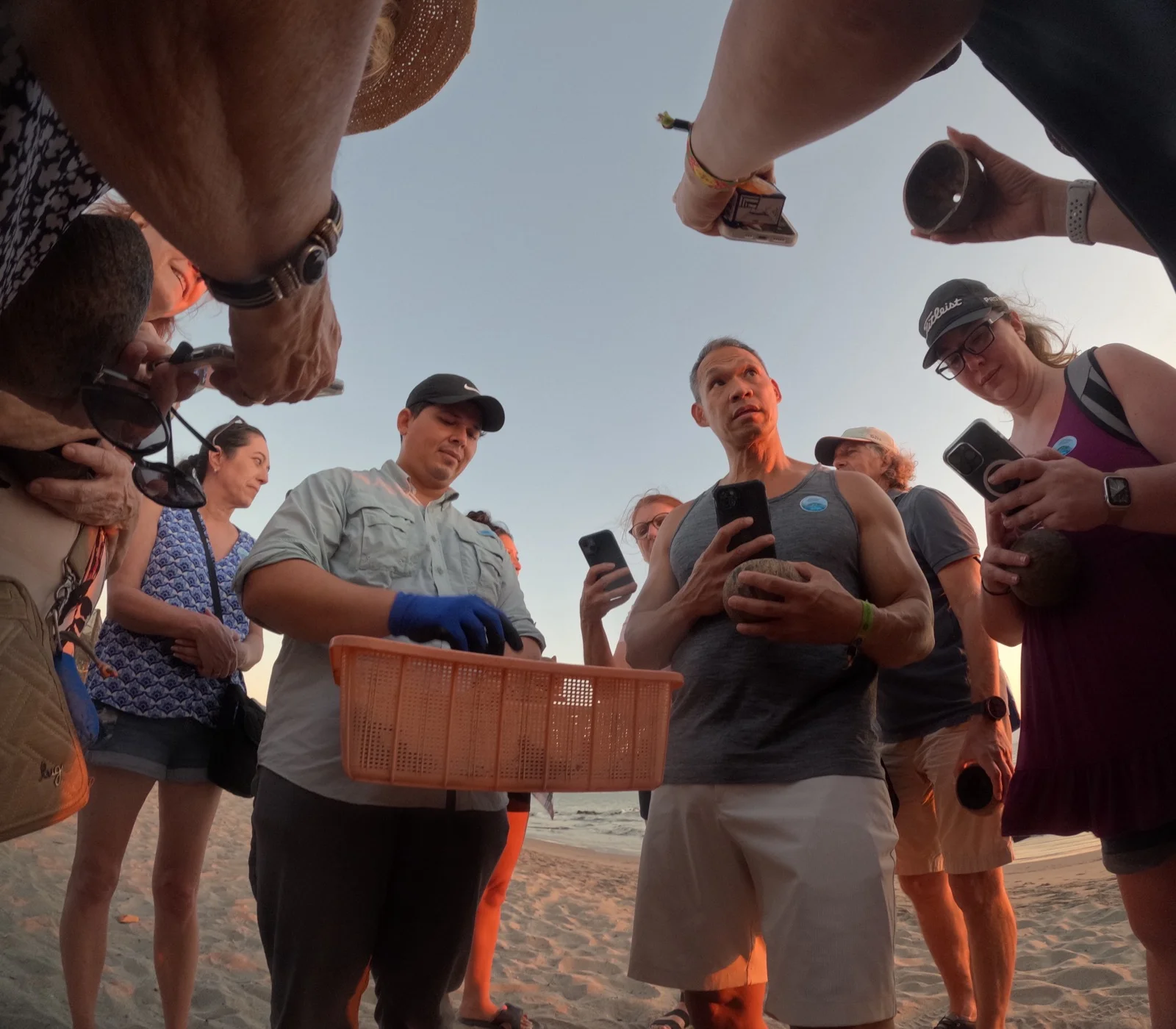 Naturalist guide briefing a group of visitors on the beach before a sea turtle release