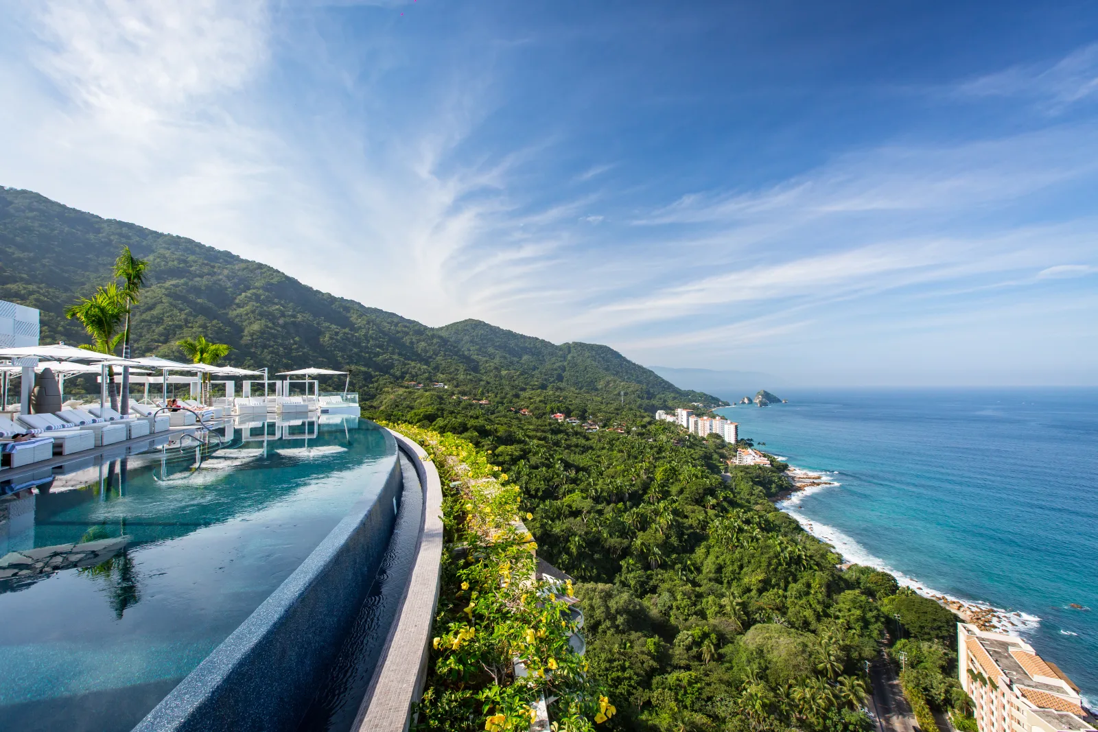 Infinity pool overlooking tropical forest and the ocean along the southern coast of Puerto Vallarta