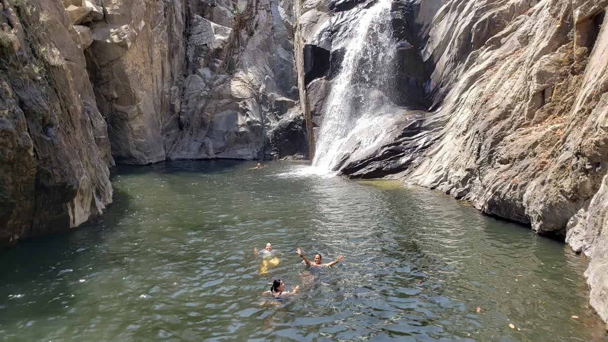 Guests swimming in the pool below the Quimixto waterfall