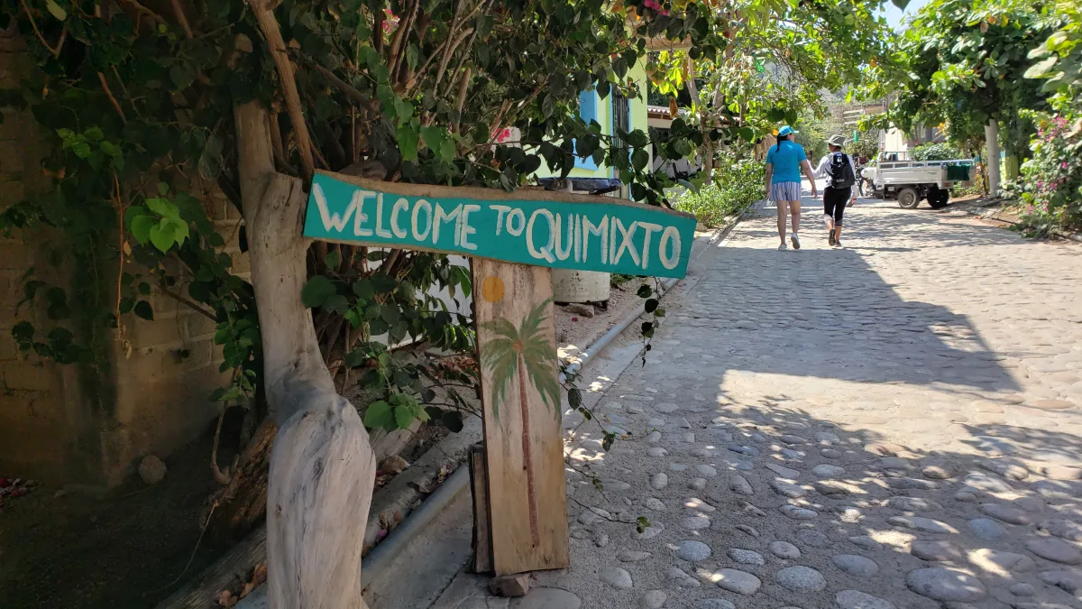 Welcome to Quimixto sign along the cobblestone village street