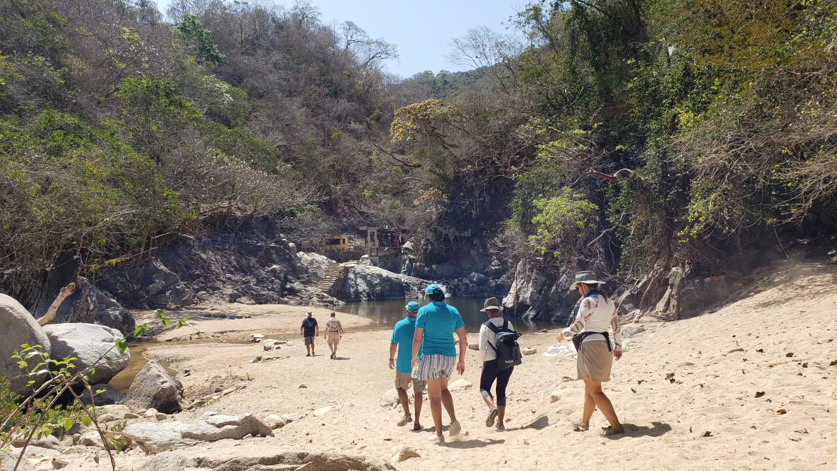 Hikers approaching the river pool near the waterfall access