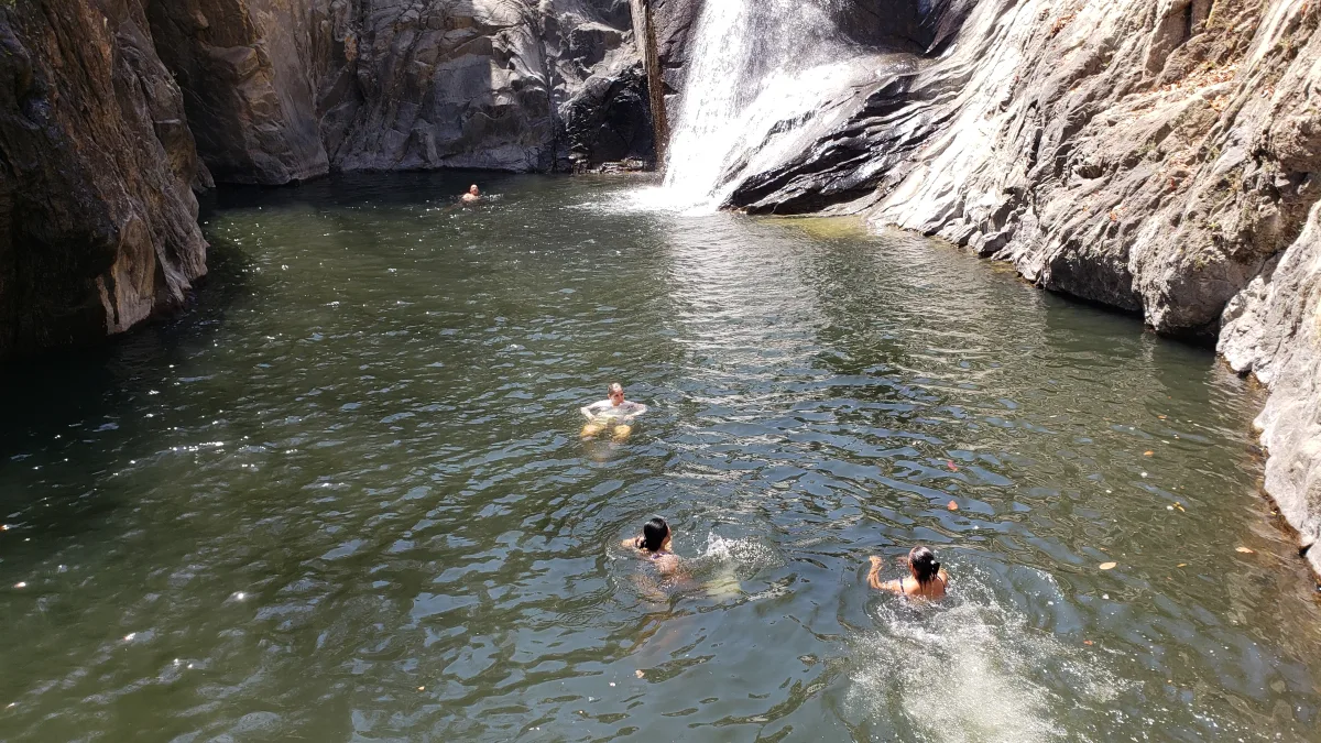 Guests swimming in the pool below the Quimixto waterfall