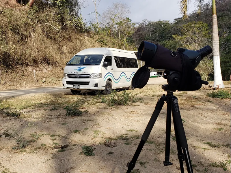 Tour van and spotting scope set up along the road