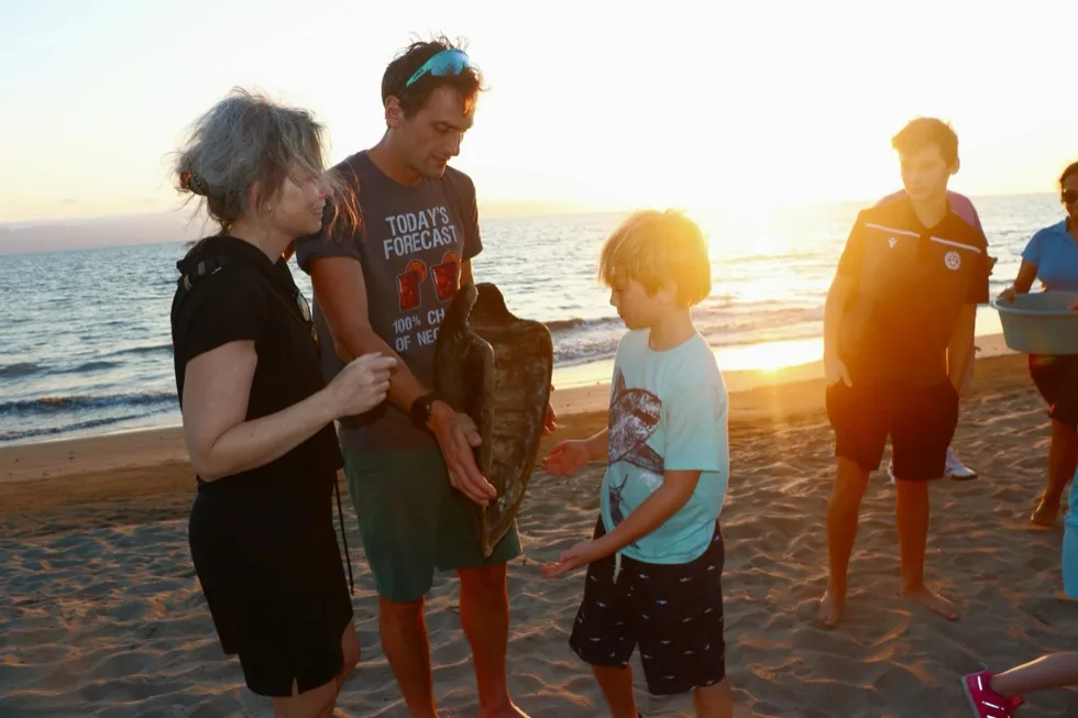 Guide showing guests a sea turtle shell during the educational talk at sunset