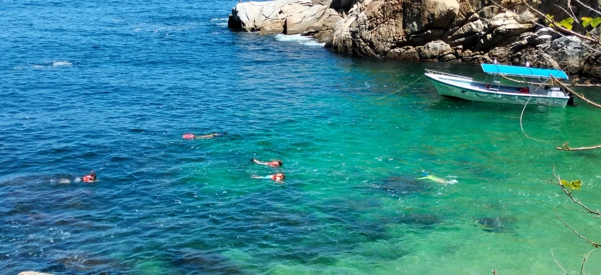 Aerial view of snorkelers and a private boat in the clear waters near Yelapa