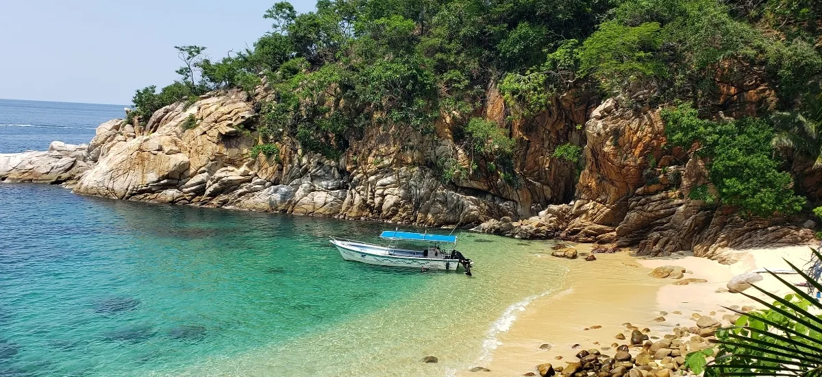 Private tour boat anchored at a secluded sandy beach near Yelapa